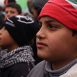 A child wears a Lebanese flag on his head at a demonstration aga