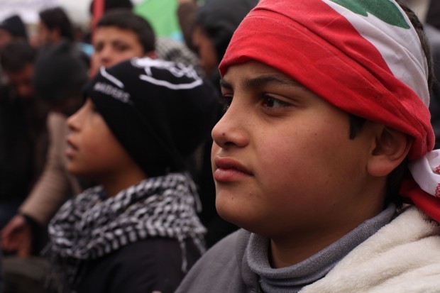 A child wears a Lebanese flag on his head at a demonstration aga